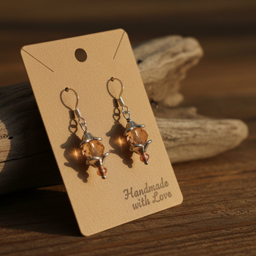Pair of earrings with orange stones on a gray background