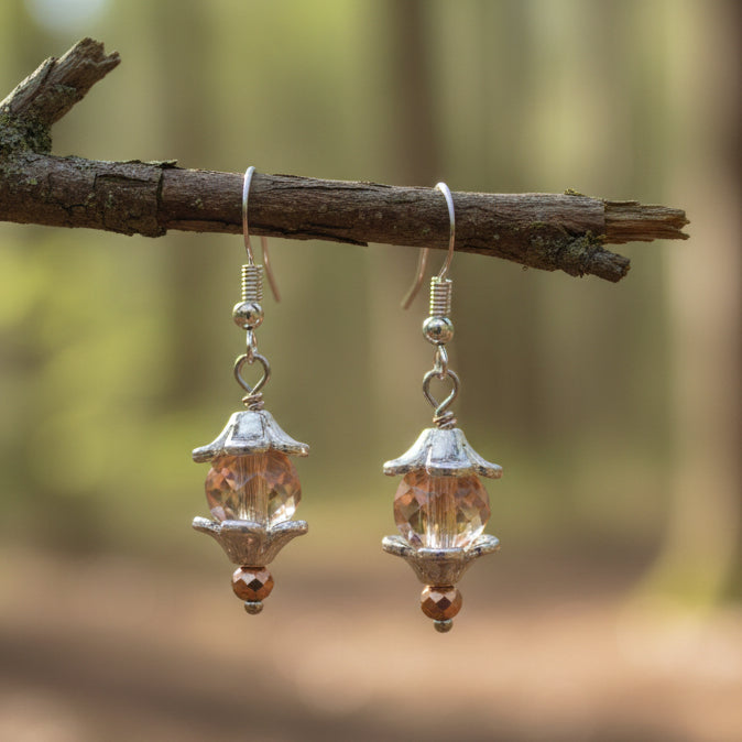 Pair of earrings with pink heart-shaped beads on a gray background