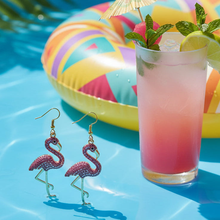 Flamingo-shaped earrings with pink and gold design on a gray background