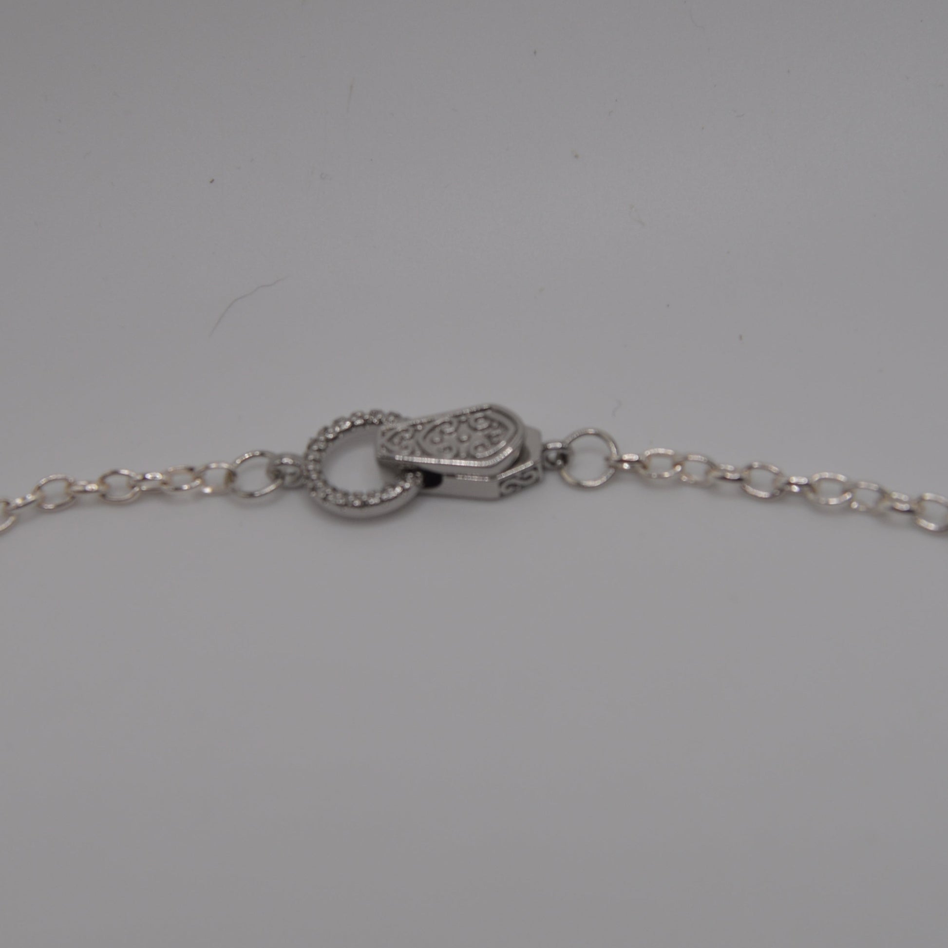 Silver necklace chain with clasp on a gray background