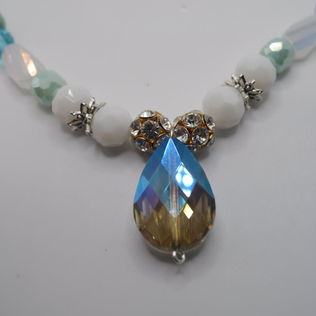Necklace with beads and a teardrop-shaped pendant on a light gray background