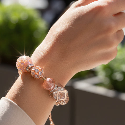Bracelet with pink and rose gold beads on a gray background