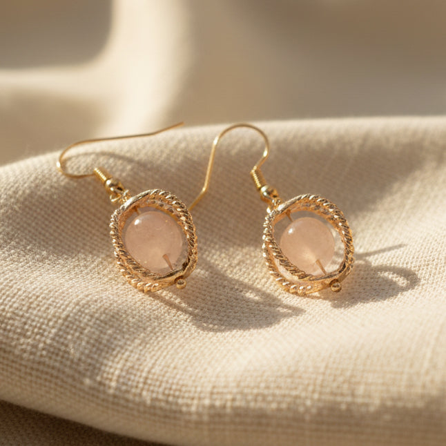 Gold earrings on a gray background