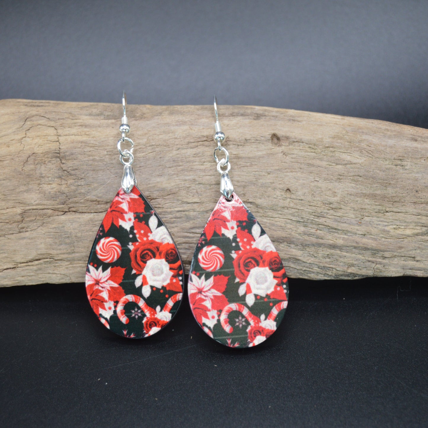 Bold red roses and candy-like swirls dance across these teardrop earrings, blending vintage romance with playful holiday charm. Lightweight and eye-catching, they’re perfect for adding a pop of festive flair to any outfit.
