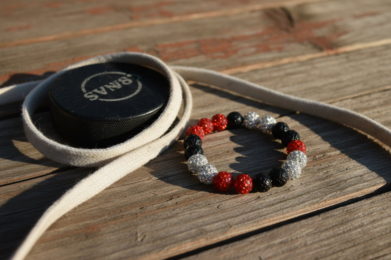 A beaded stretch bracelet featuring alternating matte black, glossy red, and faceted clear rhinestone beads, photographed on a plain light gray background.
