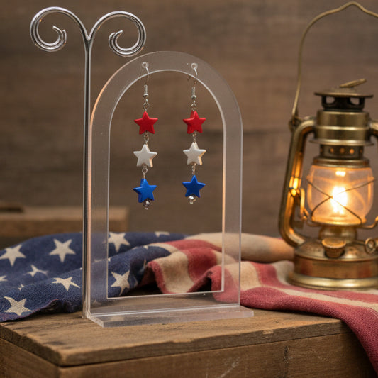 Star-shaped earrings with red, blue, and silver stars on a gray background