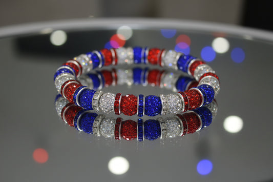 Bracelet with red, blue, and clear beads on a gray background