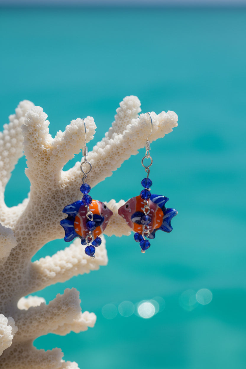 Pair of fish-shaped earrings with blue and orange details on a gray background