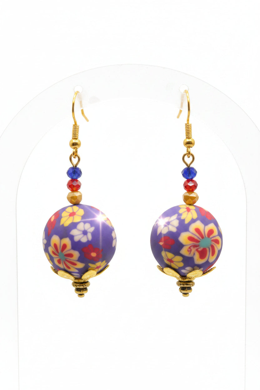Colorful floral-patterned earrings with gold accents on a gray background